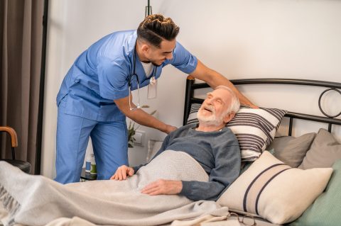 Experienced nurse positioning the patient in bed